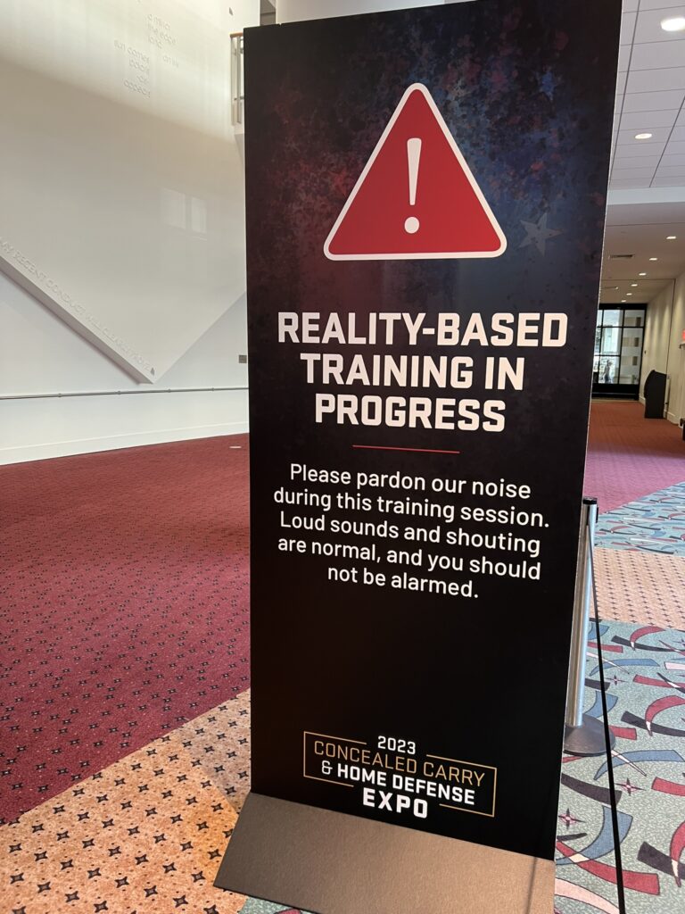 A sign discussing the realistic training at the USCCA expo
